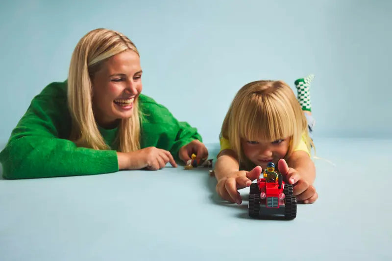 Le tracteur agricole rouge avec remorque et moutons - City